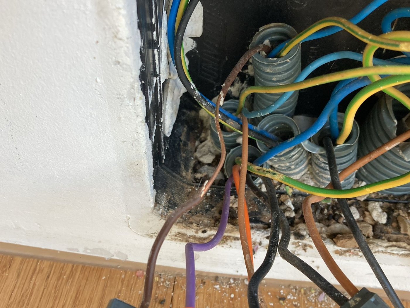 Beschädigte Verkabelung in einer Wanddurchführung durch Nagerbefall
